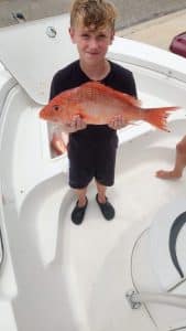 young boy holding snapper fish