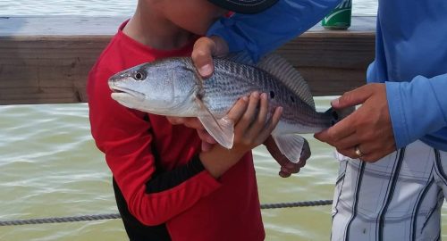 boy holding redfish with 2 spots